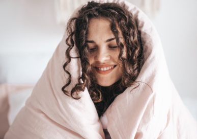 woman cozied up with comforter