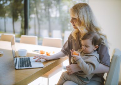 Mom using laptop and holding baby